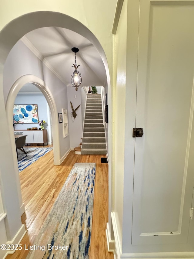 2302 Woodford Pl, Louisville, KY 40205 - foyer featuring arched walkways, light wood-style flooring, stairs, baseboards, and ornamental molding