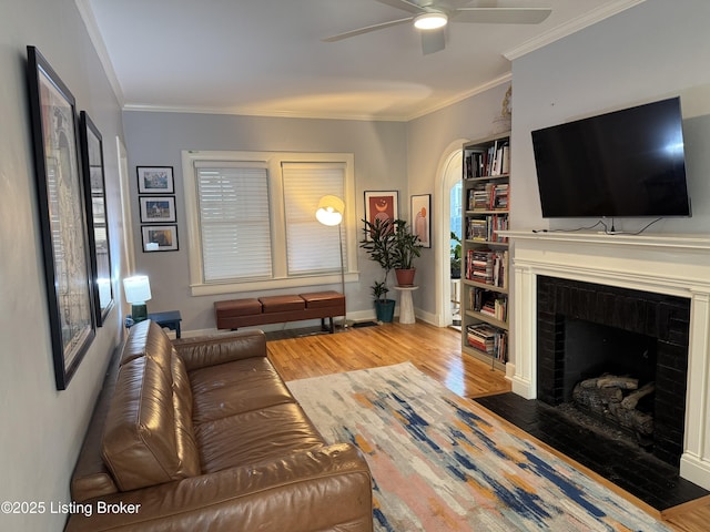 2302 Woodford Pl, Louisville, KY 40205 - living room with crown molding, a fireplace, baseboards, ceiling fan, and light wood finished floors
