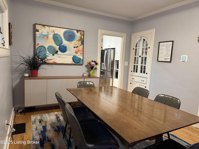 2302 Woodford Pl, Louisville, KY 40205 - dining space featuring crown molding, visible vents, and wood finished floors
