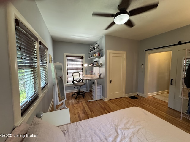2302 Woodford Pl, Louisville, KY 40205 - bedroom with a ceiling fan, baseboards, a barn door, and wood finished floors