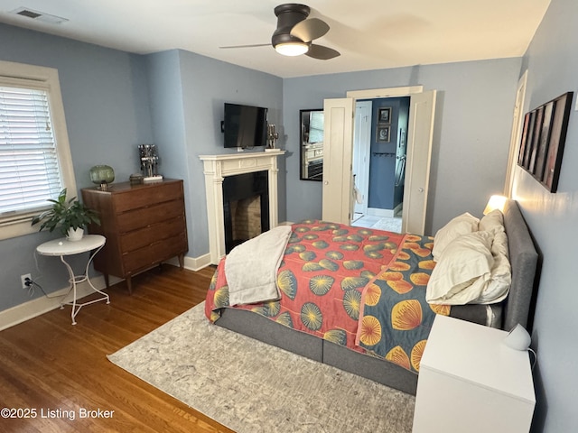 2302 Woodford Pl, Louisville, KY 40205 - bedroom with visible vents, baseboards, wood finished floors, and a fireplace
