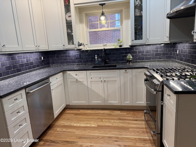 2302 Woodford Pl, Louisville, KY 40205 - kitchen featuring appliances with stainless steel finishes, white cabinetry, a sink, light wood-style floors, and extractor fan