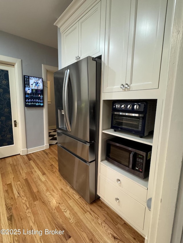 2302 Woodford Pl, Louisville, KY 40205 - kitchen with light wood finished floors, light countertops, stainless steel appliances, white cabinetry, and a toaster