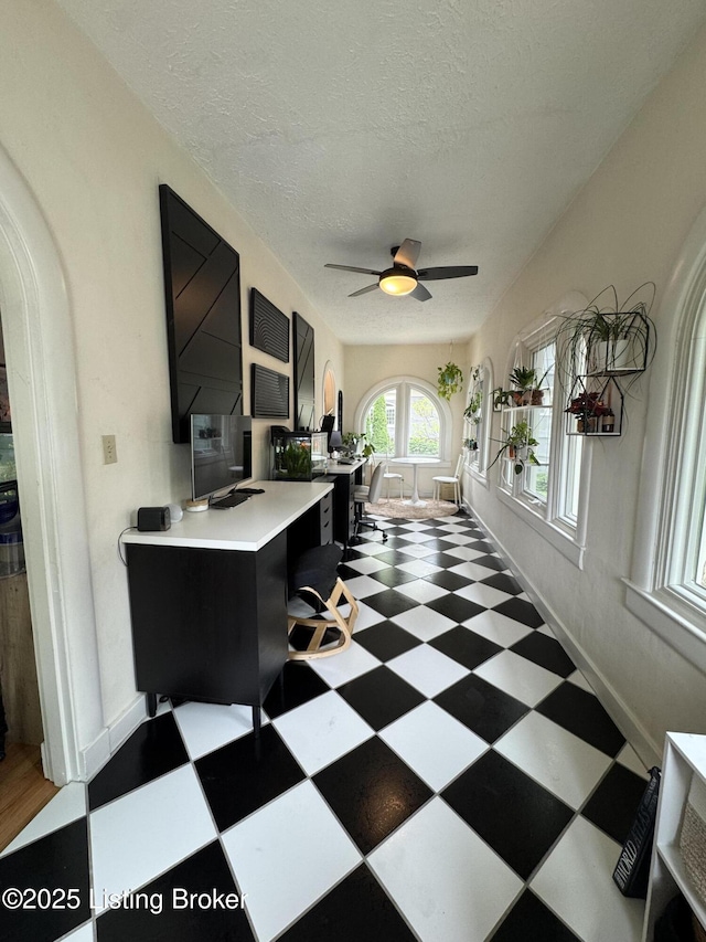 2302 Woodford Pl, Louisville, KY 40205 - office area with a ceiling fan, baseboards, a textured ceiling, tile patterned floors, and arched walkways