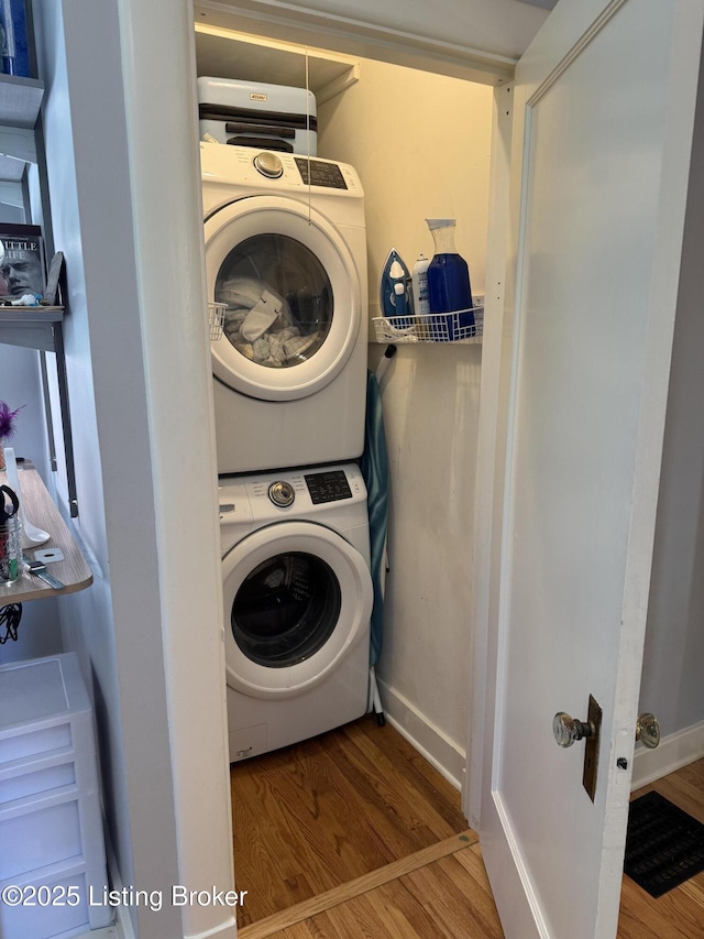 2302 Woodford Pl, Louisville, KY 40205 - clothes washing area featuring baseboards, stacked washer and dryer, laundry area, and wood finished floors