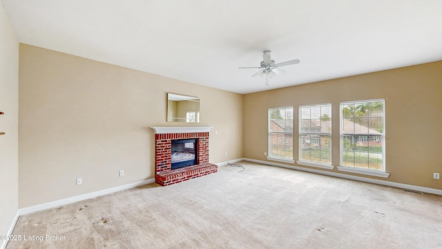 unfurnished living room featuring baseboards, a brick fireplace, carpet, and ceiling fan