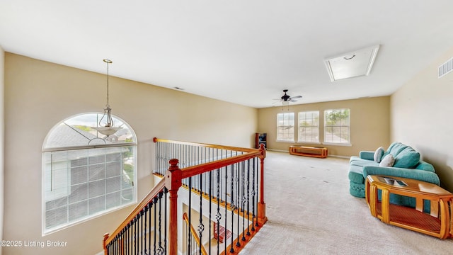 interior space with carpet floors, visible vents, and an upstairs landing