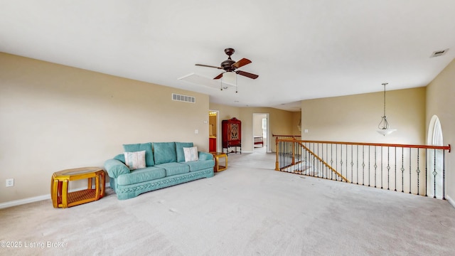 living area with visible vents, carpet floors, and ceiling fan