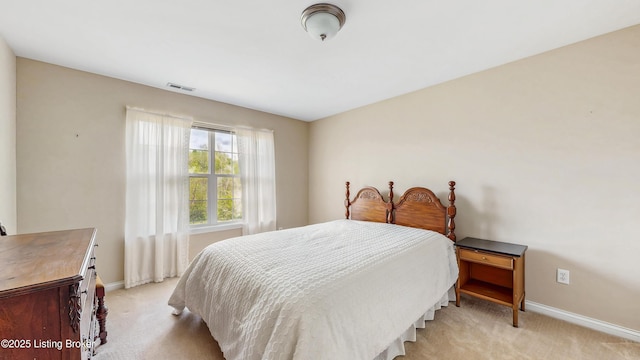 bedroom featuring baseboards, light carpet, and visible vents