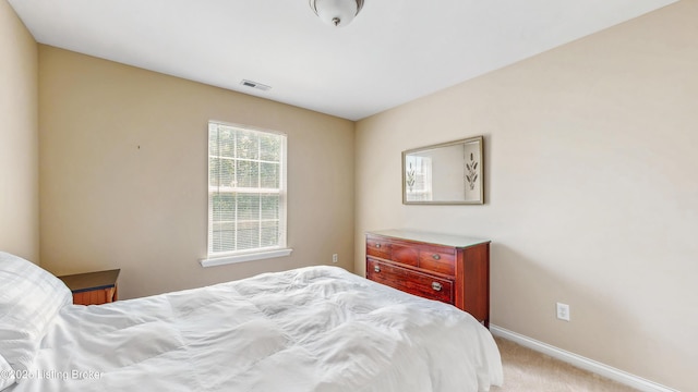 carpeted bedroom featuring visible vents and baseboards