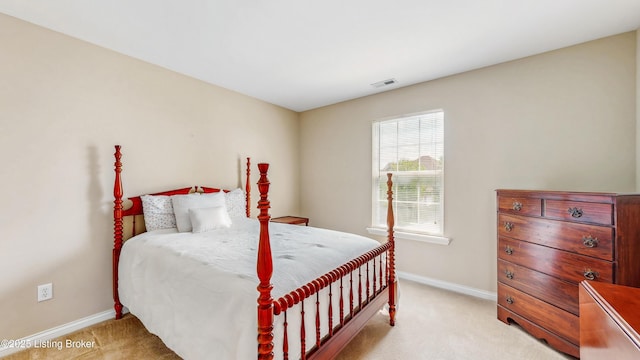 bedroom featuring visible vents, baseboards, and light colored carpet