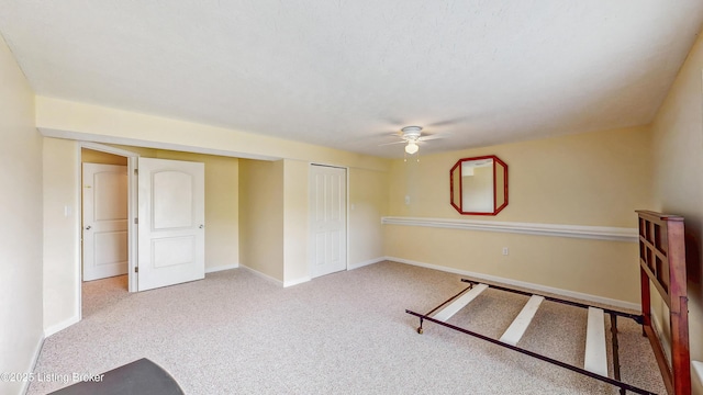 carpeted empty room with baseboards and a ceiling fan