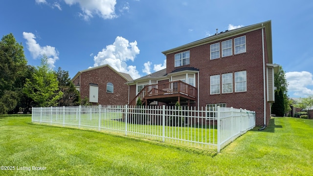 rear view of house with fence, a yard, and brick siding