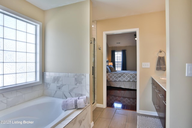 ensuite bathroom with vanity, ensuite bathroom, baseboards, and a bath