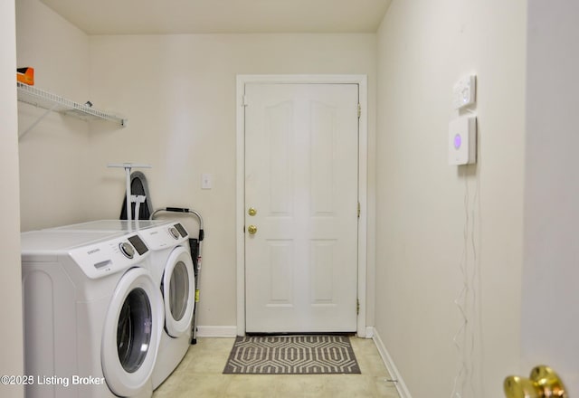 washroom with baseboards, light tile patterned floors, laundry area, and washer and clothes dryer