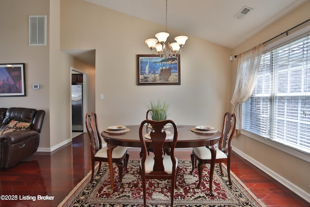 dining space featuring baseboards, a notable chandelier, wood finished floors, and visible vents