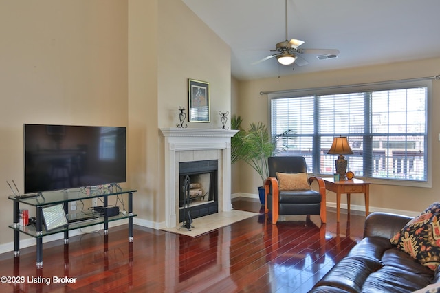 living room featuring ceiling fan, baseboards, wood finished floors, lofted ceiling, and visible vents