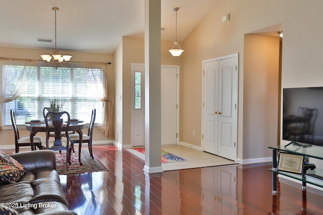 living area featuring visible vents, a chandelier, wood finished floors, and lofted ceiling