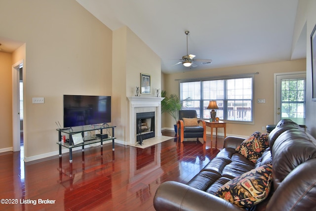 living area with a ceiling fan, plenty of natural light, wood finished floors, and a tile fireplace