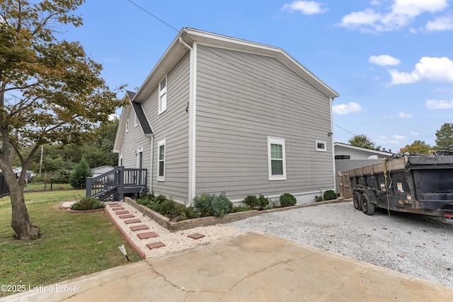 view of home's exterior with a lawn, fence, and a deck