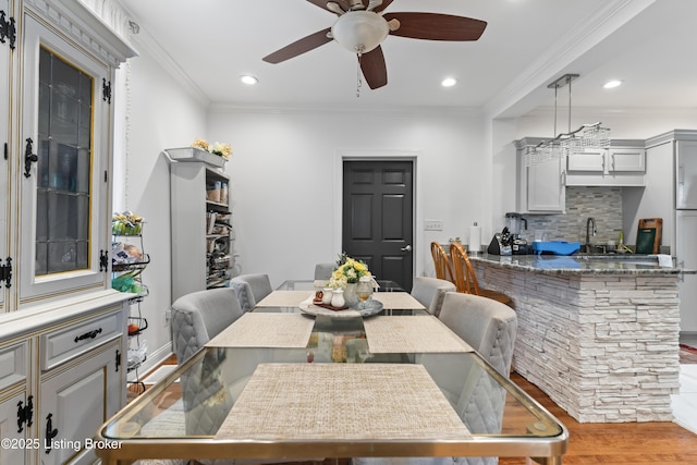 dining space featuring crown molding, ceiling fan, and wood finished floors