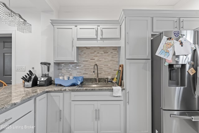 kitchen with a sink, stainless steel fridge with ice dispenser, decorative backsplash, and white cabinetry