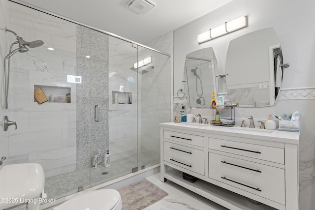 bathroom featuring toilet, visible vents, a shower stall, and marble finish floor