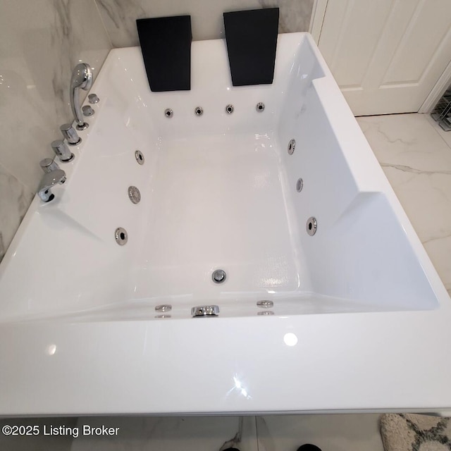 bathroom with a tub with jets