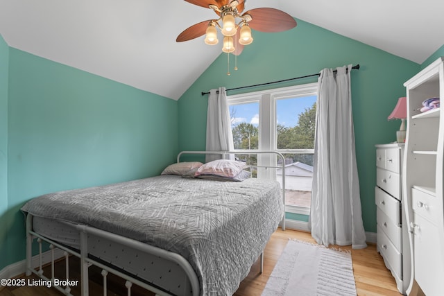 bedroom featuring baseboards, ceiling fan, wood finished floors, and lofted ceiling