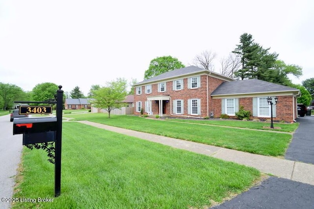 colonial home with a front lawn and brick siding
