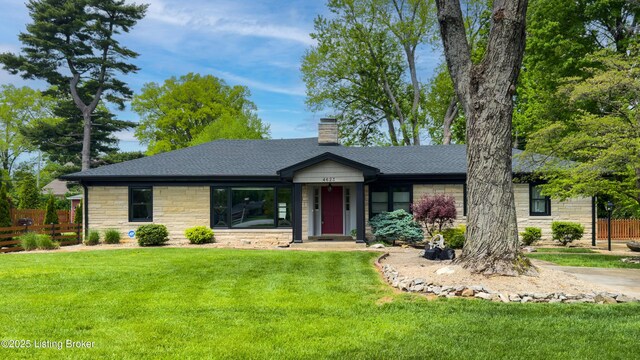 single story home featuring a chimney, fence, a front yard, and stone siding