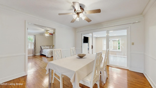 dining area with a ceiling fan, baseboards, ornamental molding, and light wood-style flooring