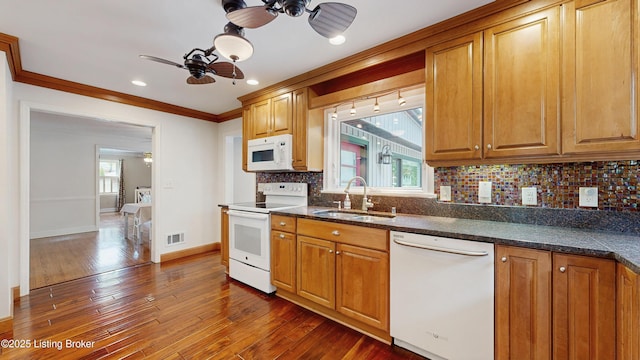 kitchen featuring a ceiling fan, visible vents, a sink, ornamental molding, and white appliances