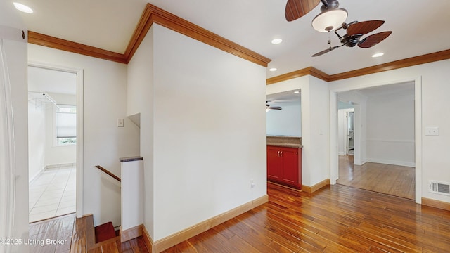 empty room featuring crown molding, a ceiling fan, and hardwood / wood-style floors