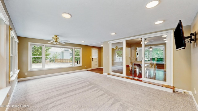 unfurnished living room featuring carpet flooring, a ceiling fan, and baseboards