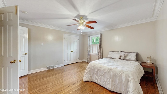 bedroom featuring crown molding, baseboards, light wood-type flooring, and visible vents