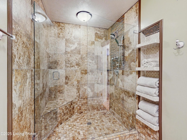 bathroom featuring a shower stall and a textured ceiling