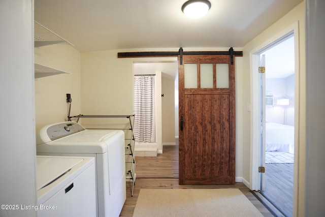 9500 Galene Dr, Louisville, KY 40299 - laundry area with washing machine and clothes dryer, laundry area, a barn door, light wood-style flooring, and baseboards