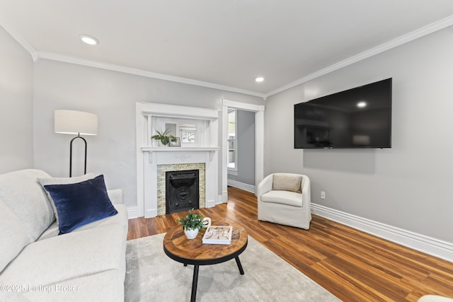 living room with crown molding, recessed lighting, baseboards, and wood finished floors
