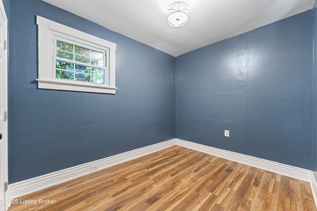 empty room featuring baseboards and wood finished floors