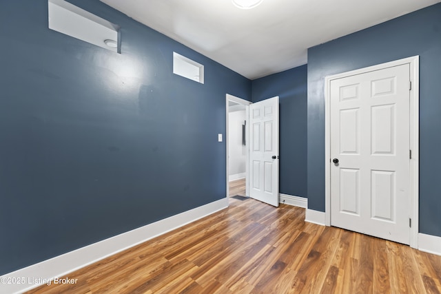 unfurnished bedroom with baseboards and wood finished floors