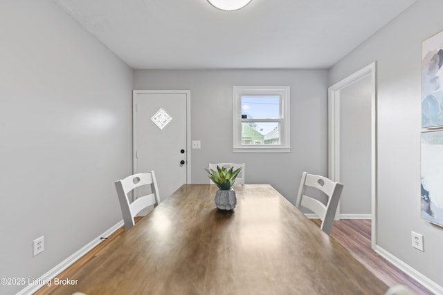 unfurnished dining area featuring baseboards and wood finished floors