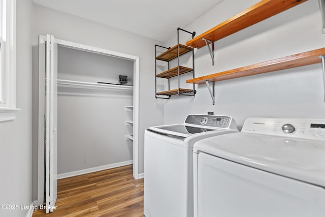 washroom featuring baseboards, laundry area, wood finished floors, and washer and clothes dryer