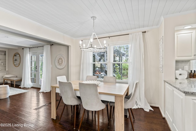 dining space featuring an inviting chandelier, ornamental molding, and dark wood finished floors