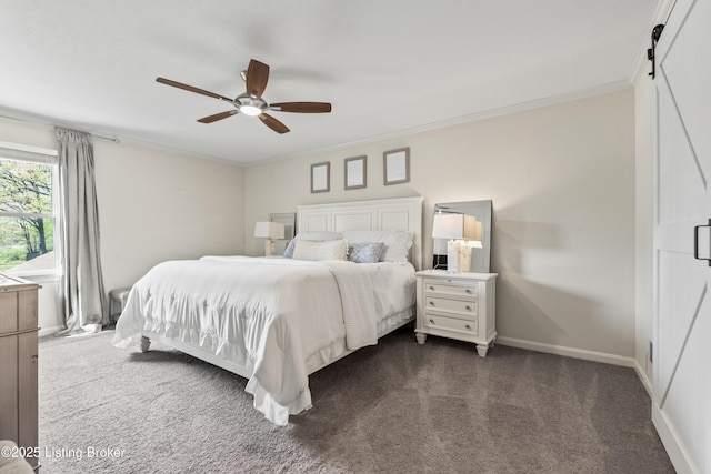bedroom featuring a barn door, dark colored carpet, a ceiling fan, baseboards, and ornamental molding