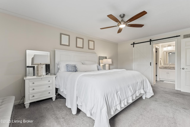 carpeted bedroom with a barn door, visible vents, ornamental molding, and ceiling fan