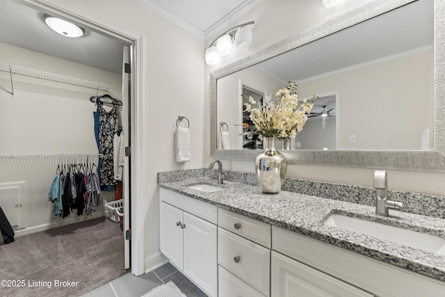 bathroom with crown molding, a sink, and a spacious closet