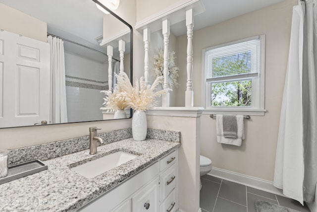 bathroom with toilet, baseboards, tile patterned flooring, and vanity