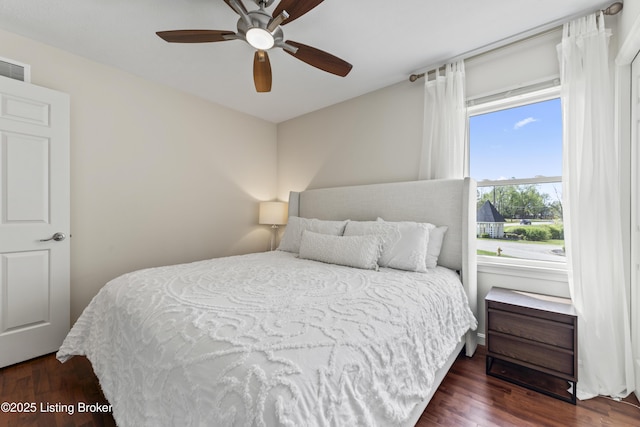 bedroom with a ceiling fan, wood finished floors, and visible vents