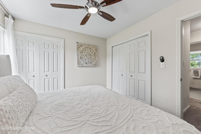 carpeted bedroom with baseboards, a ceiling fan, and multiple closets